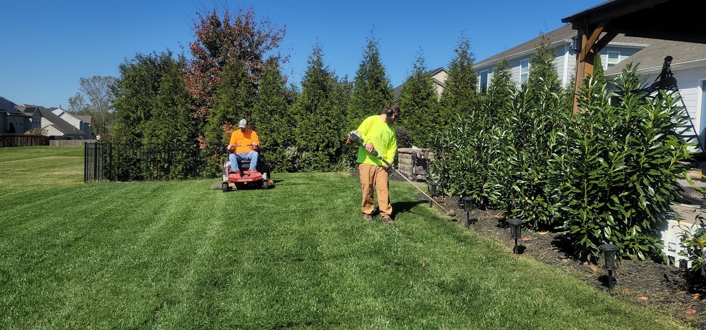Evergreen Yard Works crew mowing and maintaining a lush green lawn in Eugene, Oregon